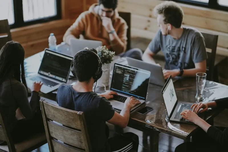 A group of people collaborating around laptops